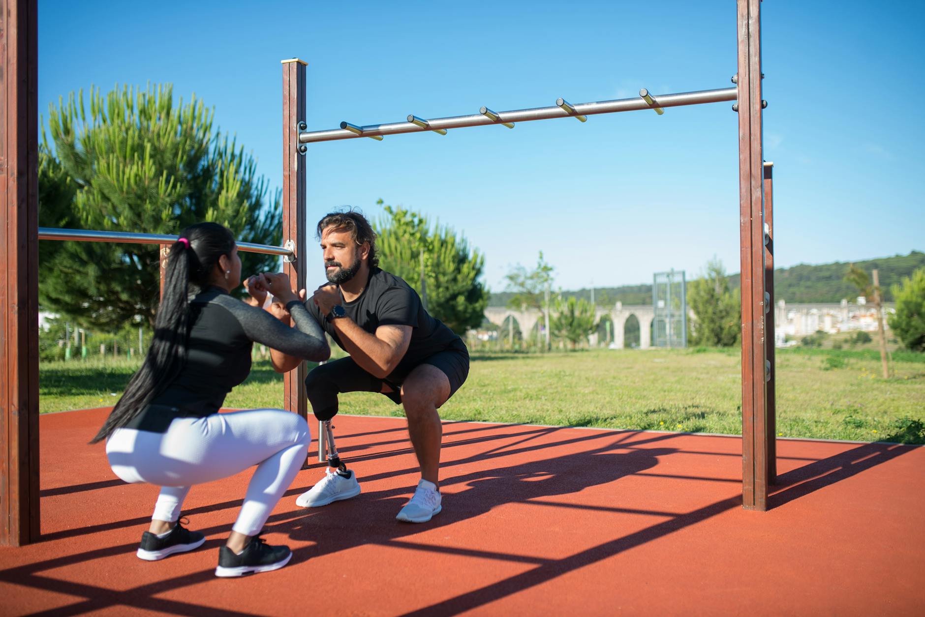 Mężczyzna z protezą nogi i kobieta ćwiczą razem na zewnątrz