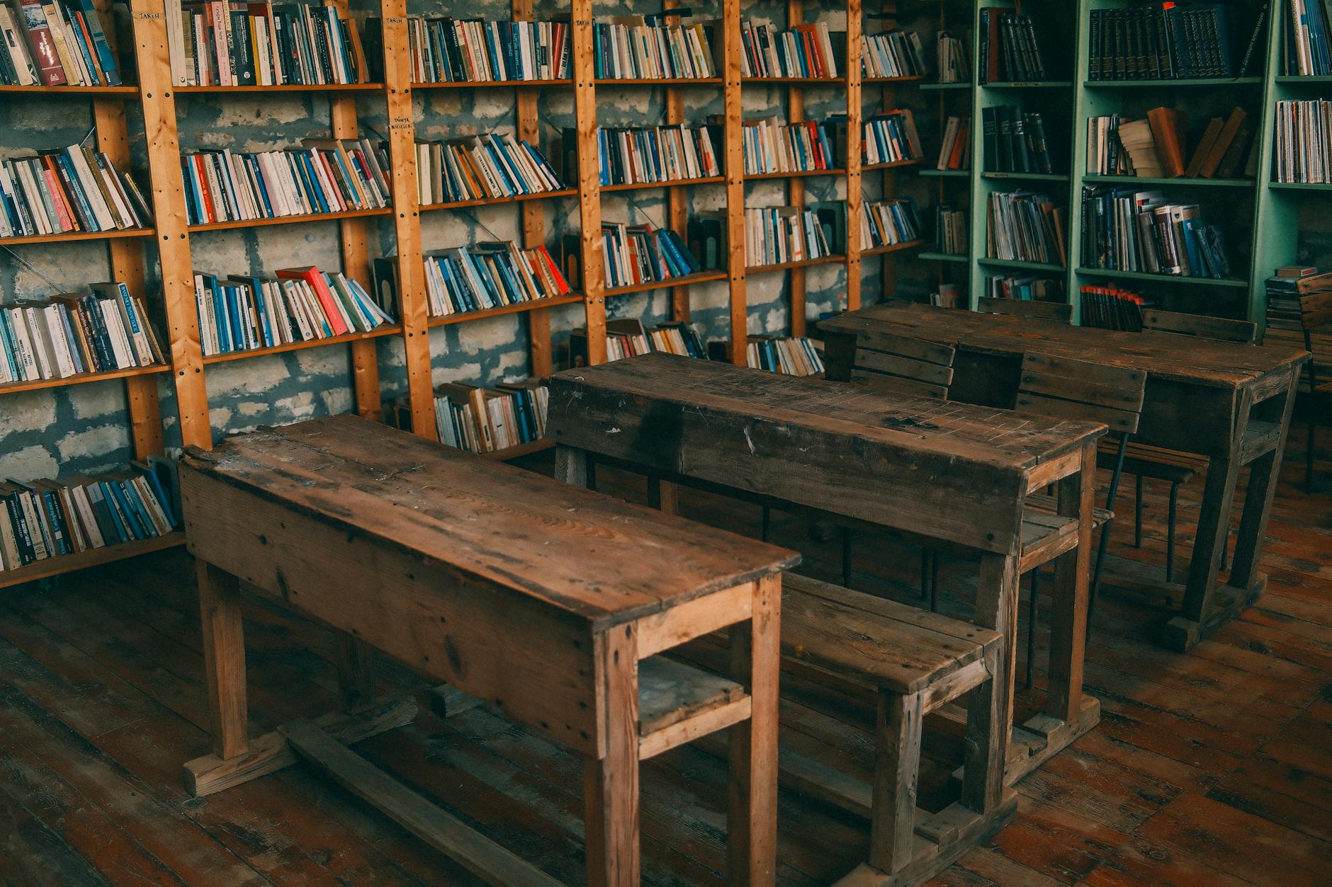 Rustykalna klasa z drewnianymi ławkami i regałami pełnymi książek