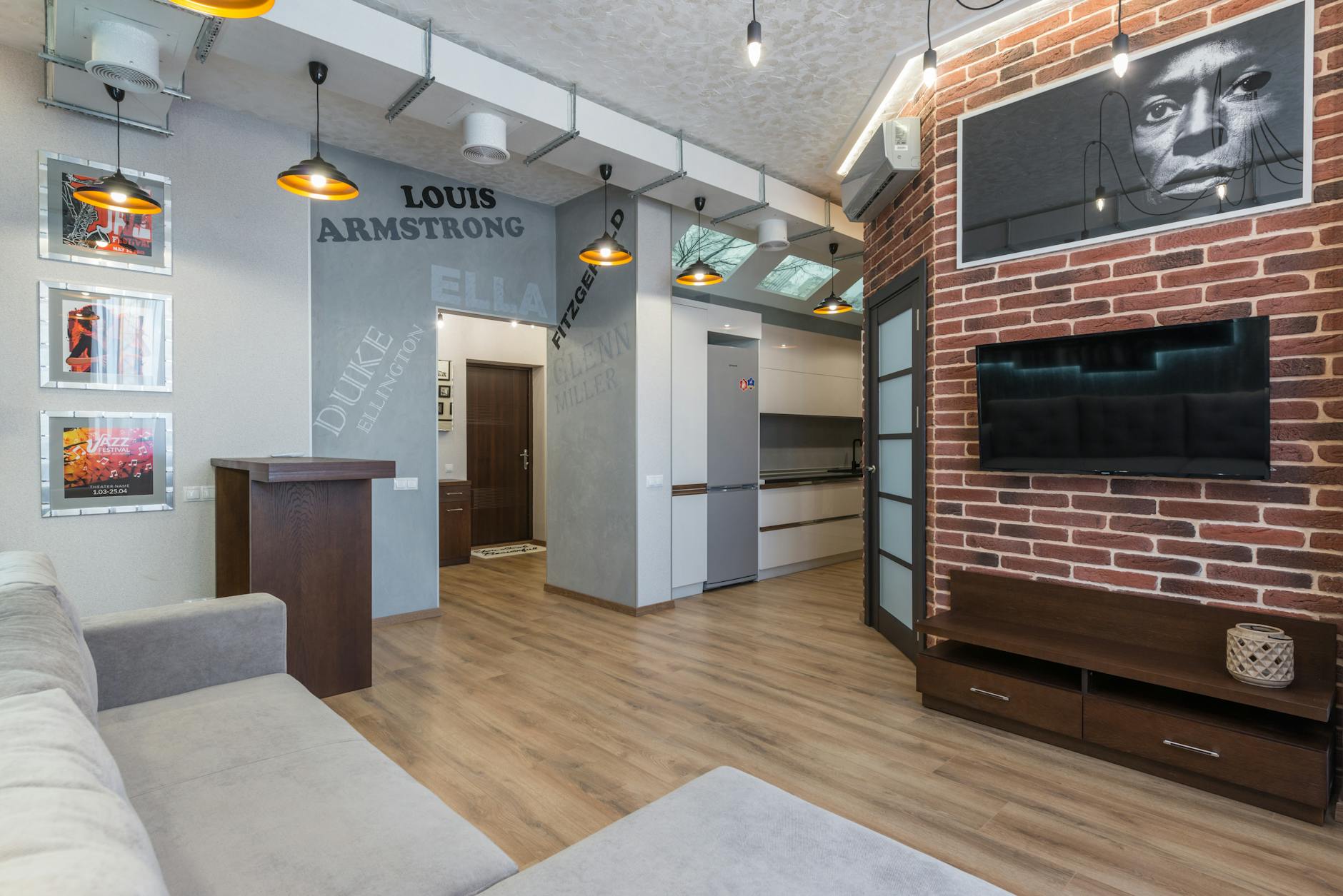 Salon z ceglaną ścianą, plakatami jazzowymi i nowoczesnymi meblami